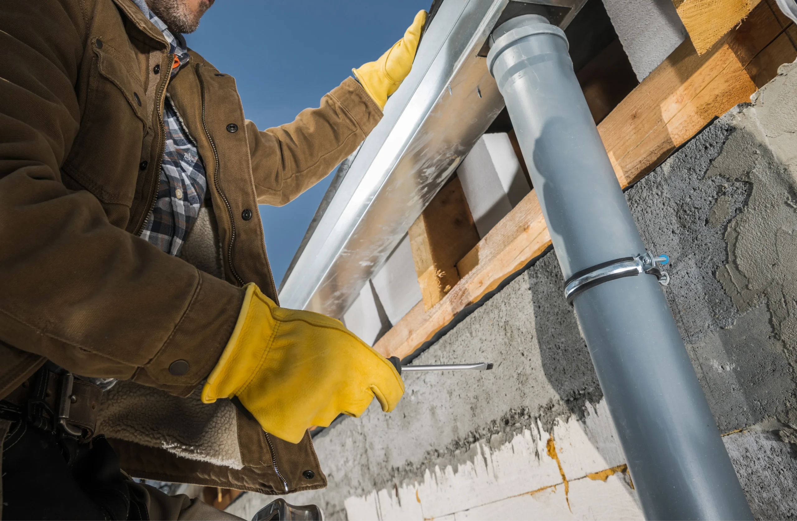 worker finishing installation of eaves roof gutters photo 1
